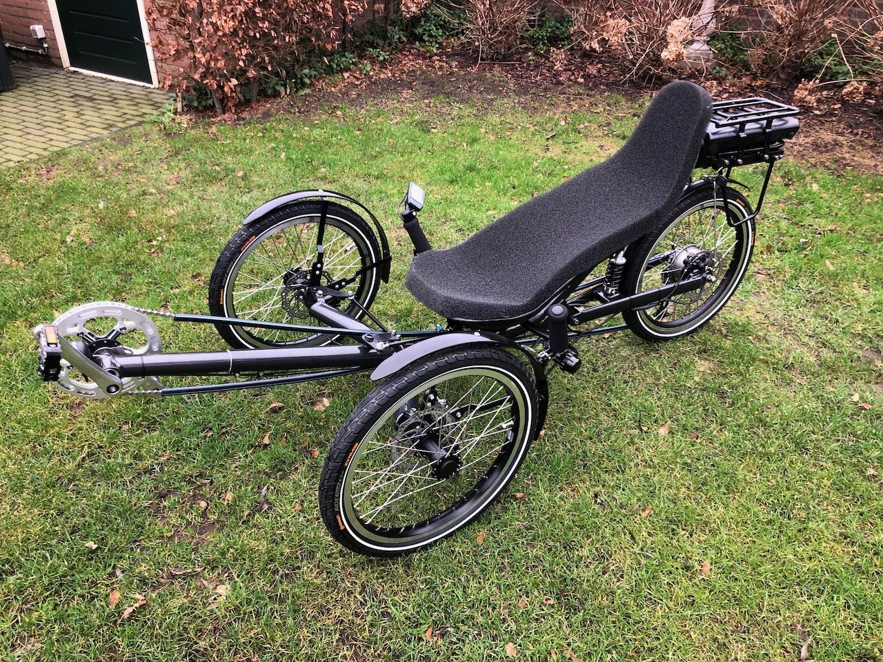 Schuinaanzicht: USVA Bike, driewieler trike męt trapondersteuning en aangepaste ligstoel